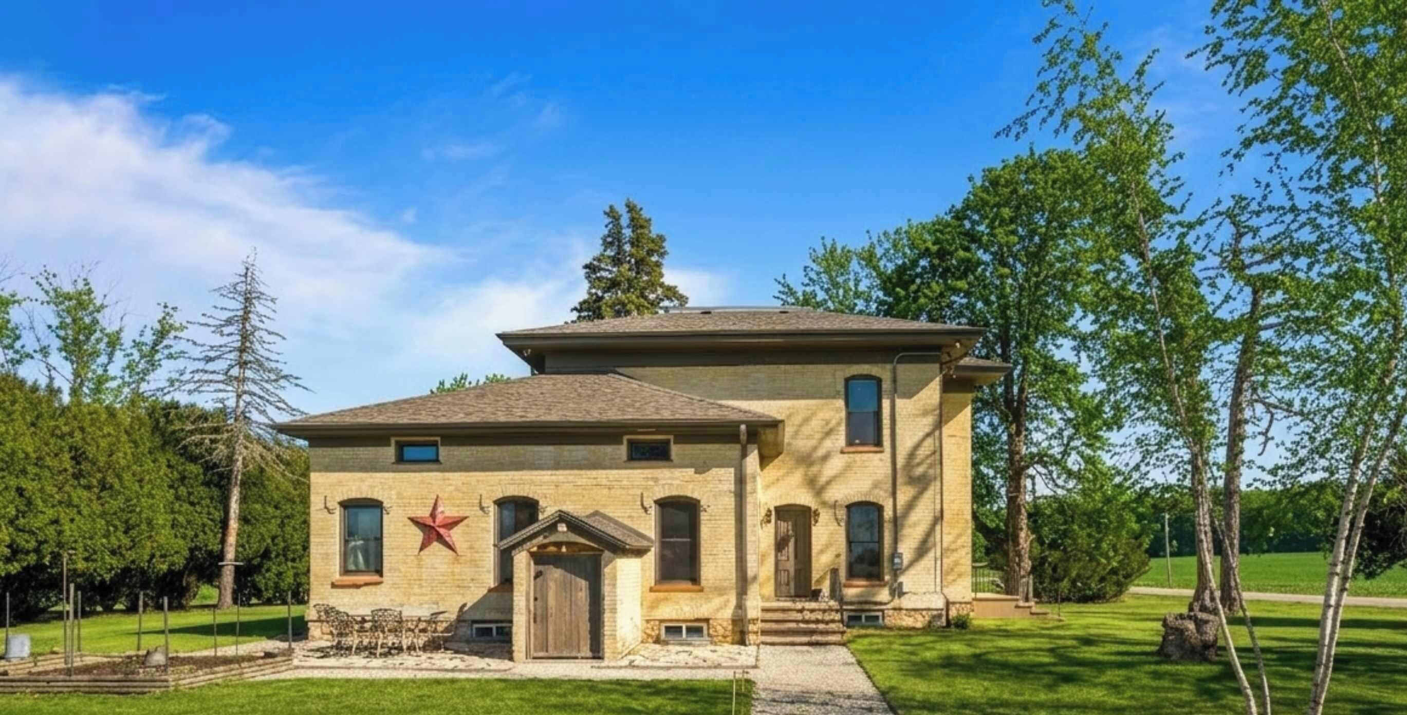 Front exterior | Historic 1868 Johnston Farmhouse near Kettle Moraine in East Troy, WI — Italianate architecture, mature trees, country privacy for weddings, family gatherings, and farm-style