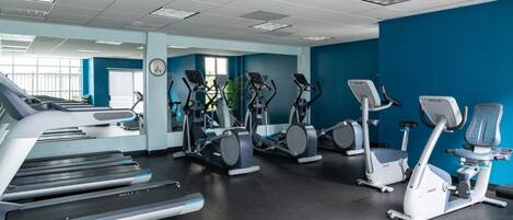 A gym with treadmills, elliptical machines, and stationary bikes.