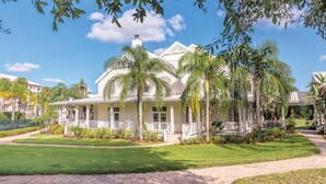 A large, white colonial-style building with a central dome, surrounded by lush greenery and palm trees. - Orlando 2BR Deluxe at Kingstown Reef – Pools, Near Disney & Universal (Orlando)