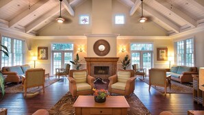 A spacious living room with a fireplace, multiple seating areas, and large windows. - Orlando 2BR Deluxe at Kingstown Reef – Pools, Near Disney & Universal (Orlando)