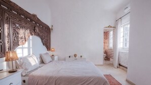 A bedroom with a large bed, a nightstand, a lamp, and a decorative headboard. - Maison l'Étoile de Sidi Bou Saïd  S 09 (Sidi Bou Said)