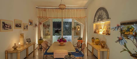 A dining area with a table, chairs, and a chandelier.