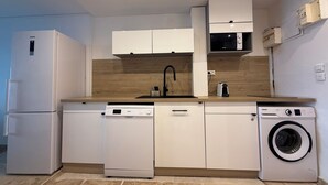 A compact kitchen with a dishwasher, washing machine, microwave, and a sink. - Cosy accommodation with sea view and swimming pool (Cul-de-Sac)