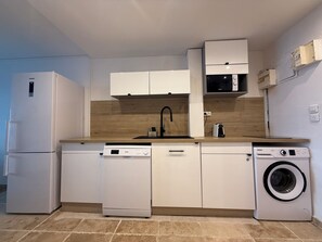 A compact kitchen with a dishwasher, washing machine, microwave, and a sink. - Cosy accommodation with sea view and swimming pool (Cul-de-Sac)
