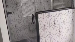 A room with geometric patterned walls, a sliding door, and a window with blinds. - Cozy Compound Retreat Near Downtown & Highways (Detroit)