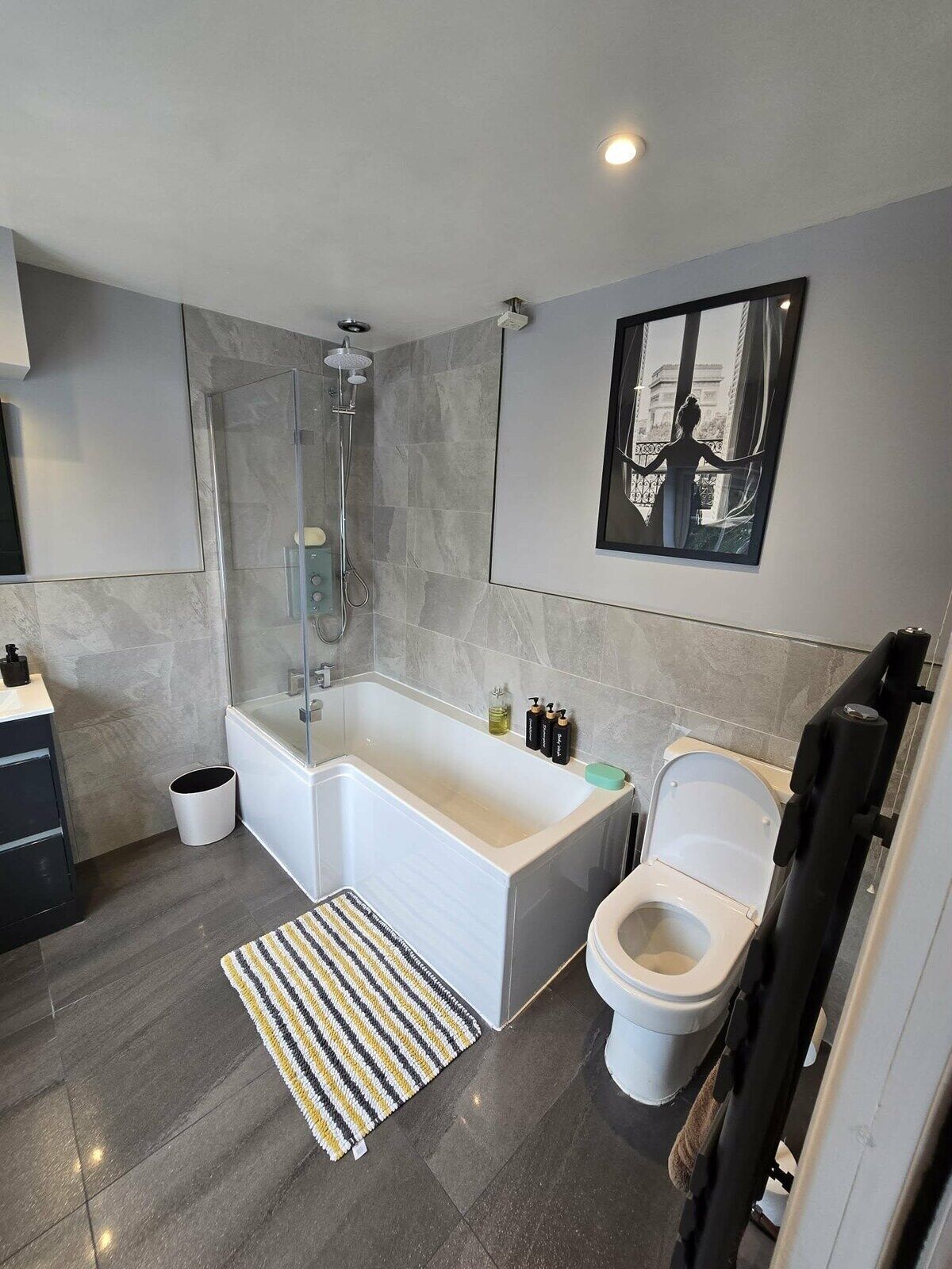 Une salle de bain moderne équipée d’une baignoire, de toilettes et d’une douche.