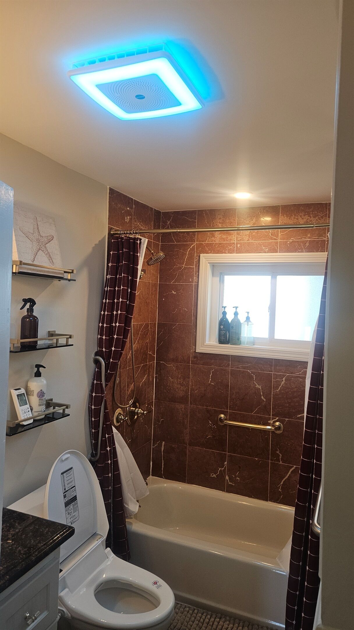 A bathroom with a bathtub, a toilet, a shower, and a window.
