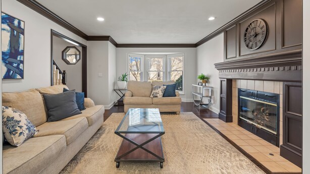 A living room with a glass coffee table, beige sofa, and a fireplace. - A Home away from home - family friendly, central (Kansas City)