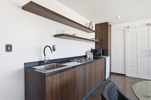 A modern kitchen with a built-in sink, wooden cabinets, and a coffee machine.