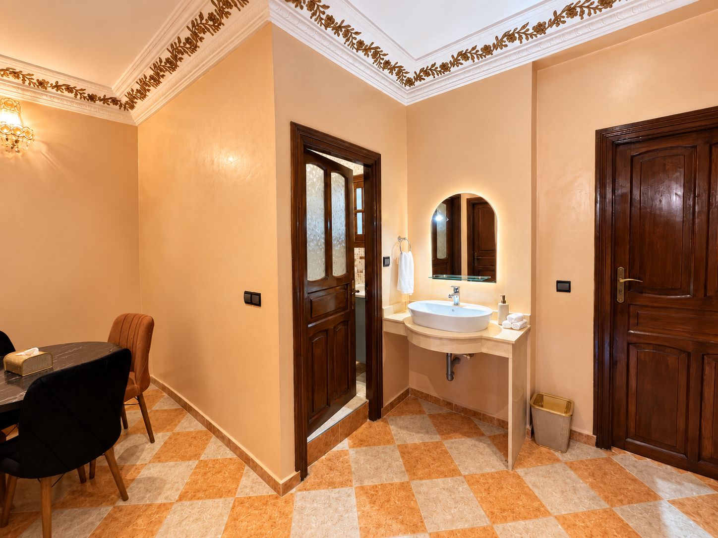 Un baño de hotel con un lavabo, espejo y dos puertas.