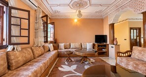 A living room with a sofa set, a coffee table, and a television. - Stay near Marrakech Airport RAK (Marrakech)