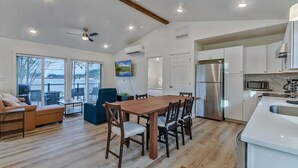 A modern kitchen with a dining area, large windows, and a view of the outdoors. - Scenic New Built Waterfront Cabin on Hammersley Inlet Olympic Peninsula (Shelton)