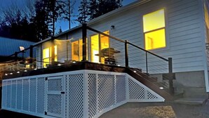 A house with a covered outdoor area, a staircase, and a metal fence. - Scenic New Built Waterfront Cabin on Hammersley Inlet Olympic Peninsula (Shelton)