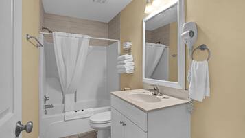 Une salle de bain équipée d’une baignoire, de toilettes, d’un lavabo et d’un miroir.