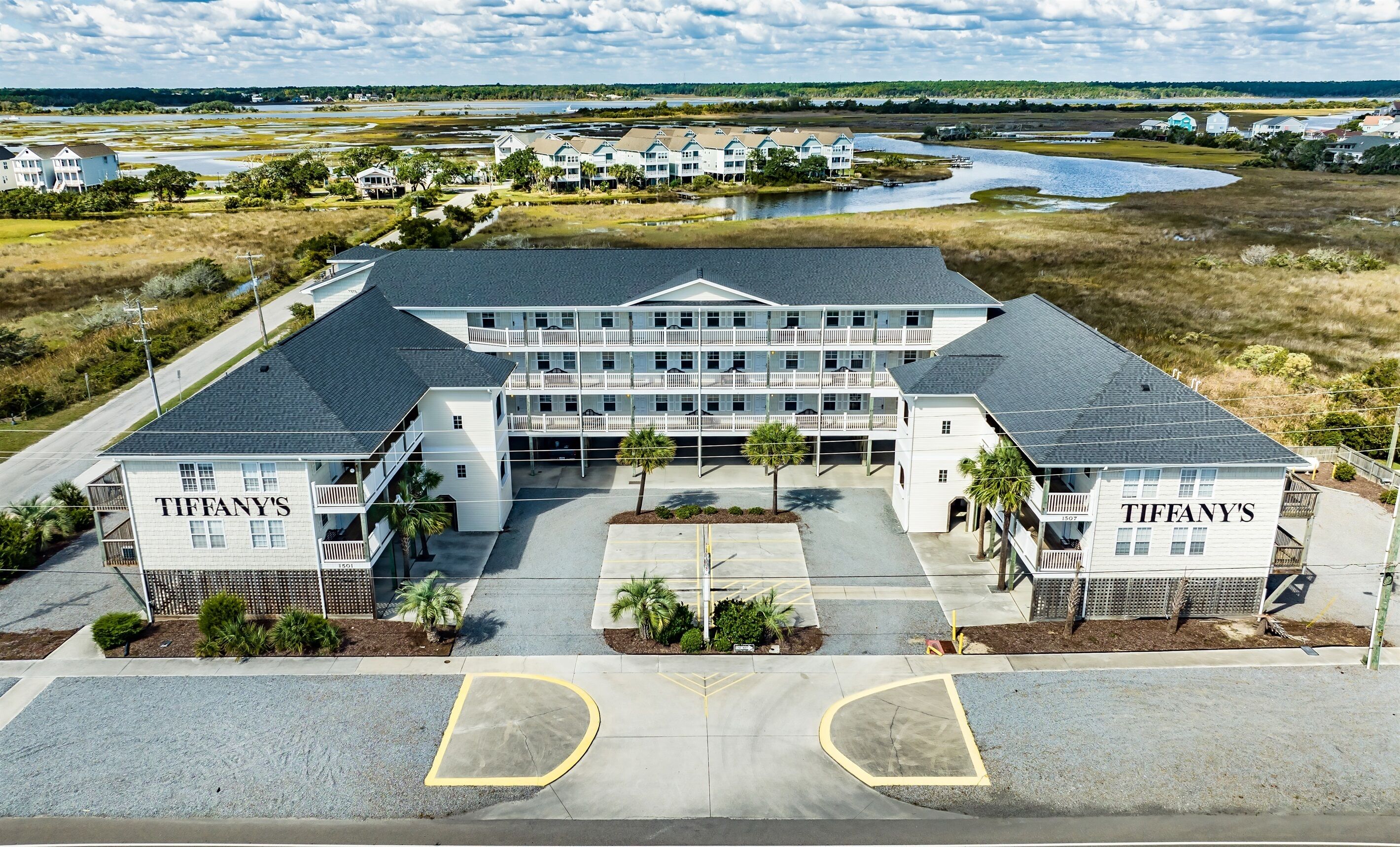 A large hotel with multiple floors, a central courtyard, and a parking lot.