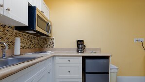 A kitchen with white cabinets, a microwave, a coffee maker, and a trash can. - Surf City Getaway - Motel Unit - Walk to Beach (Surf City)