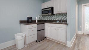 A kitchen with white cabinets, a stainless steel refrigerator, a microwave, and a coffee maker. - Surf City Getaway - Walk to Beach - Seasonal Pool (Surf City)