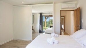 Una habitación de hotel moderna con una cama grande, un baño y vistas al exterior.