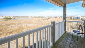 A covered porch with a view of a grassy field and a body of water. - Surf City Getaway- Walk to Beach - Seasonal Pool (Surf City)