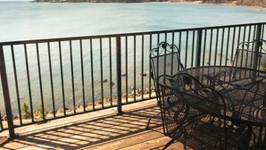 Ein Balkon mit Blick auf ruhiges Wasser und eine entfernte Küste.