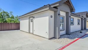 A single-story building with a flat roof, a garage door, and a small porch area.