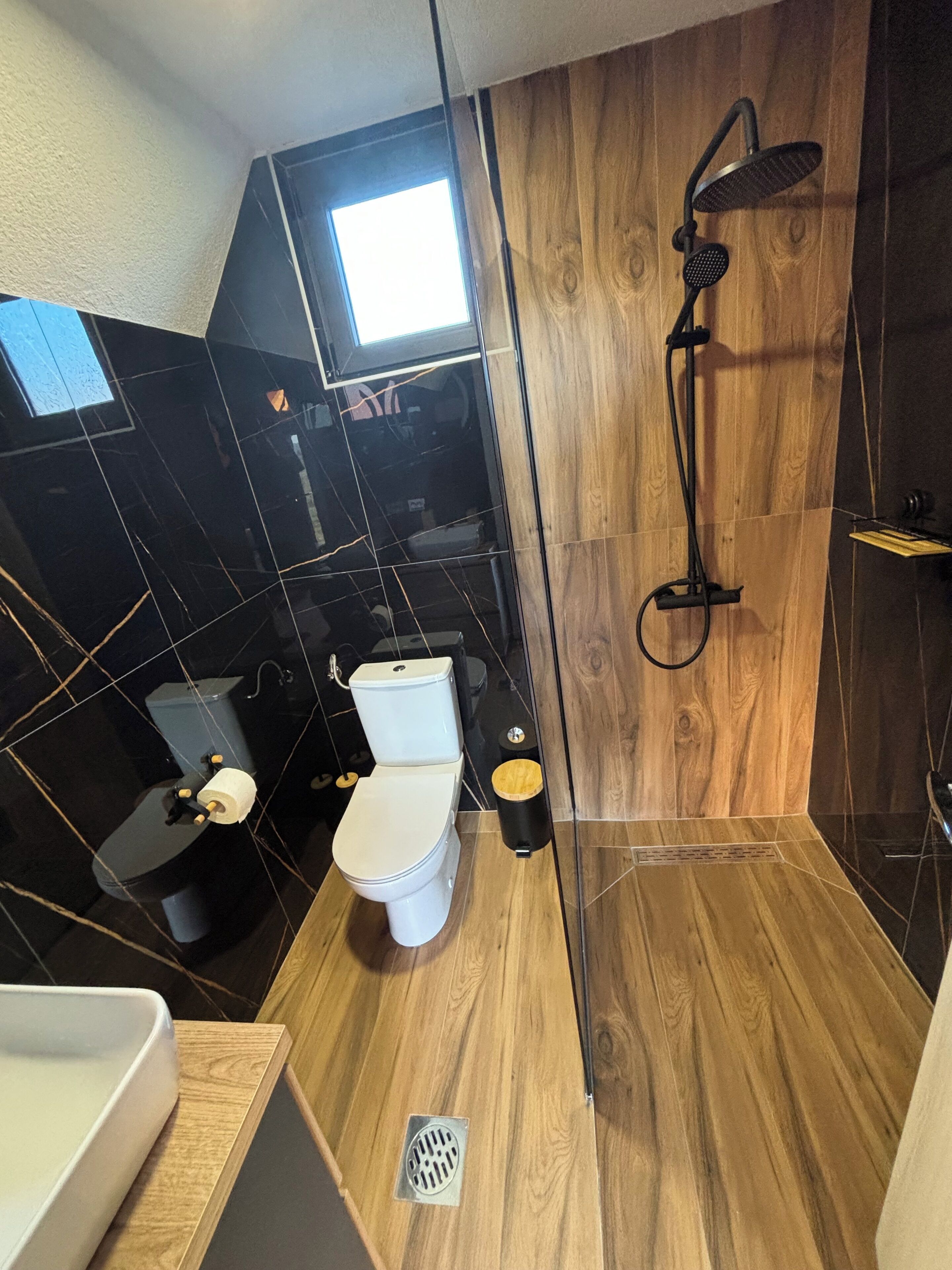 A compact bathroom with a toilet, bidet, and shower.
