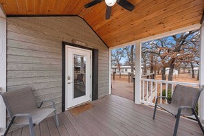 Eine überdachte Veranda mit zwei Stühlen, einer Holzbalkendecke und einer Tür mit der Aufschrift 'ZION'.