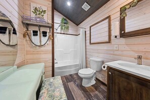A wooden interior with a bathtub, toilet, and sink. - The Resort at Fredericksburg Unit 3 (Fredericksburg)