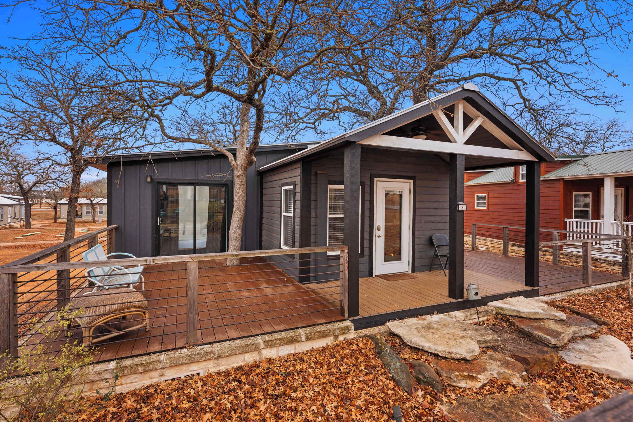 A modern house with a deck, a covered porch, and a large window.