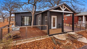 A modern house with a deck, a covered porch, and a large window. - The Resort at Fredericksburg Unit 3 (Fredericksburg)