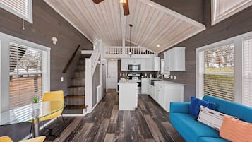 A spacious kitchen with white cabinets, a central island, and a ceiling fan.
