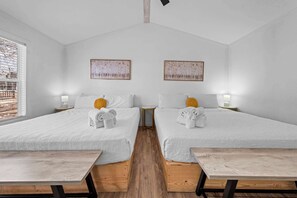 A hotel room with two beds, a wooden floor, a window with blinds, and two bedside tables with lamps. - The Resort at Fredericksburg Unit 15 (Fredericksburg)