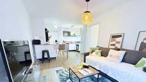 Eine moderne Wohnung mit Wohnbereich, Küche und Essplatz.