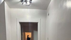 A hallway with wooden flooring, white walls, and a staircase with a black railing. - 2bedroom, No living room, EinsteinHospital & Salus University (Philadelphia)