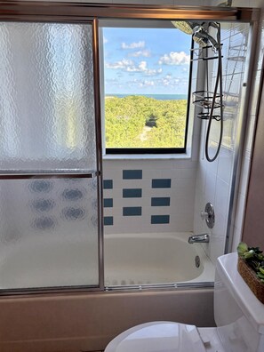 Ein Badezimmer mit Glastür, Badewanne und Dusche.