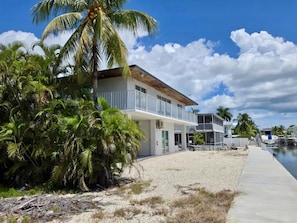 A beachfront property with a two-story building, a covered patio, and a boat dock. - Sunset, Waterfront Key Largo House, with a 100' Boat Dock (Key Largo)