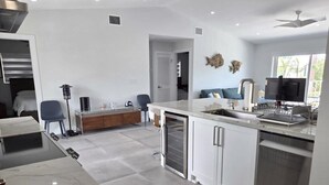 A modern kitchen with a marble countertop, white cabinetry, and a built-in dishwasher. - Sunset, Waterfront Key Largo House, with a 100' Boat Dock (Key Largo)