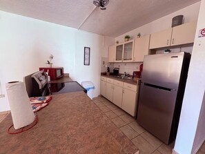 A compact kitchen with a refrigerator, microwave, and sink. - Spacious Family Getaway in Guayama – Comfort Meets Convenience (Guayama)