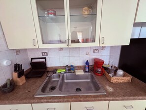 A kitchen with a double sink, cabinets, and various kitchen items. - Spacious Family Getaway in Guayama – Comfort Meets Convenience (Guayama)