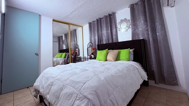 Ein Schlafzimmer mit einem großen Bett, einem Schminktisch, einem Spiegel und einer Tür.