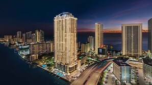 A high-rise hotel with a rooftop pool, located near a body of water with a sunset view. - 3BR Oceanview HYDE – Free Parking, No Resort Fees (Hollywood)