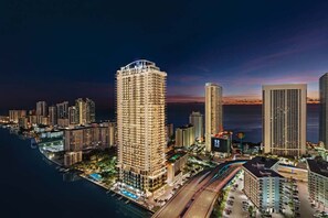 A high-rise hotel with a rooftop pool, located near a body of water with a sunset view. - 3BR Oceanview HYDE – Free Parking, No Resort Fees (Hollywood)