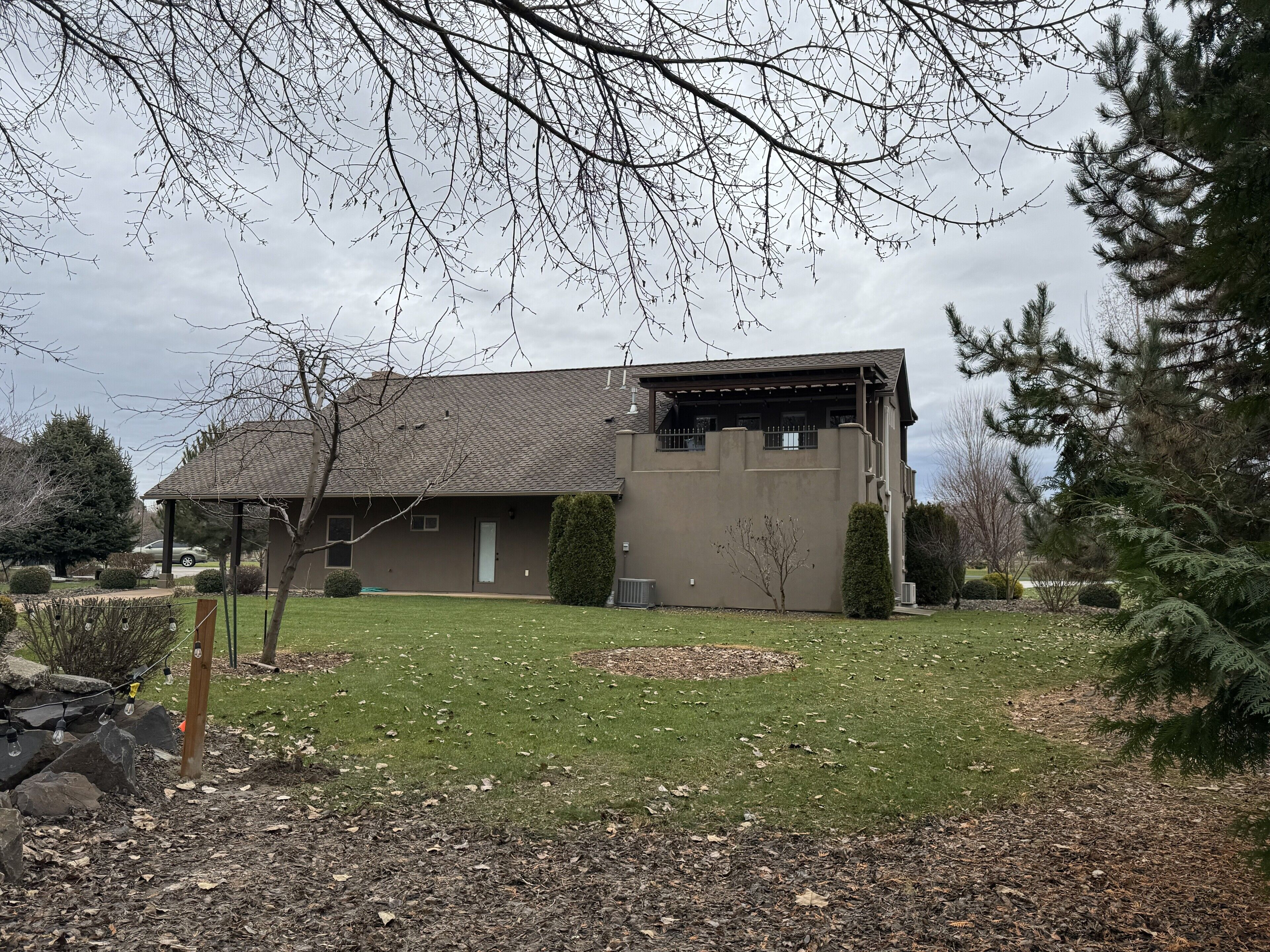 A residential house with a sloped roof, a covered porch, and a well-maintained lawn.