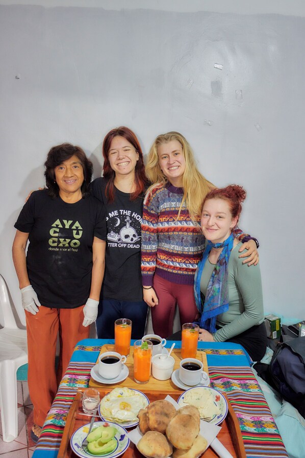 A group of people at a table with breakfast items and drinks. - TuKasa - Hospedaje Libertad (Ayacucho)