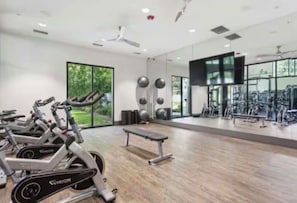 A gym with stationary bikes, a bench, and exercise equipment.