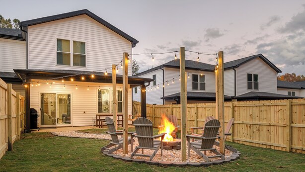 A backyard with a fire pit, outdoor seating, and string lights. - NEW MODERN 1500 SQ FT RETREAT, 65” TV, Fire Pit, Family & Pet Friendly, Sleeps 6 (Boiling Springs)