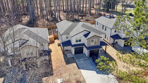 A residential area with multiple houses, including a central house with a garage and a covered patio. - NEW MODERN 1500 SQ FT RETREAT, 65” TV, Fire Pit, Family & Pet Friendly, Sleeps 6 (Boiling Springs)