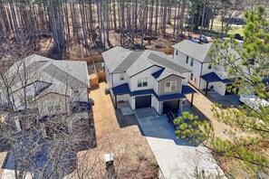 A residential area with multiple houses, including a central house with a garage and a covered patio. - NEW MODERN 1500 SQ FT RETREAT, 65” TV, Fire Pit, Family & Pet Friendly, Sleeps 6 (Boiling Springs)