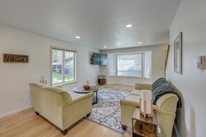 Ein geräumiges Wohnzimmer mit großem Fenster, Kamin und gemütlicher Sitzecke.