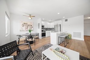 Un appartement moderne comprenant un coin repas, une cuisine et un espace de vie.
